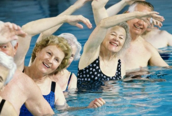 Personas de tercera edad haciendo deporte en el agua, aquafitness 