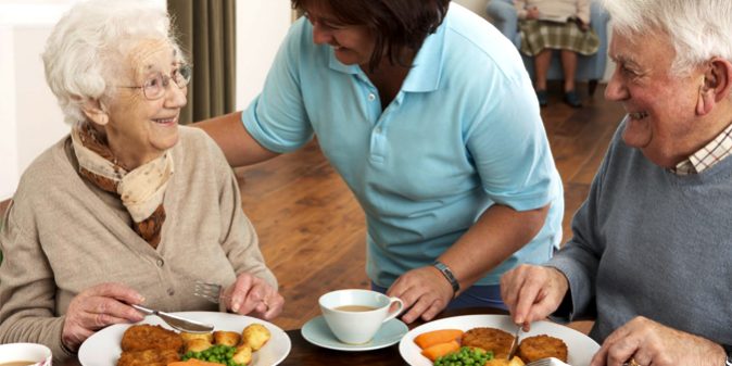 alimentacion-saludable Cuidadora sirviendo un menú saludable a personas de la tercera edad