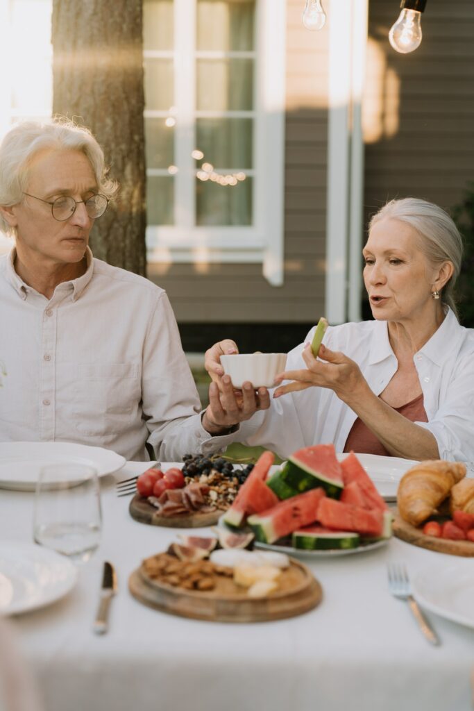 Dos ancianos tomando alimentos refrescantes para evitar la deshidratación en verano