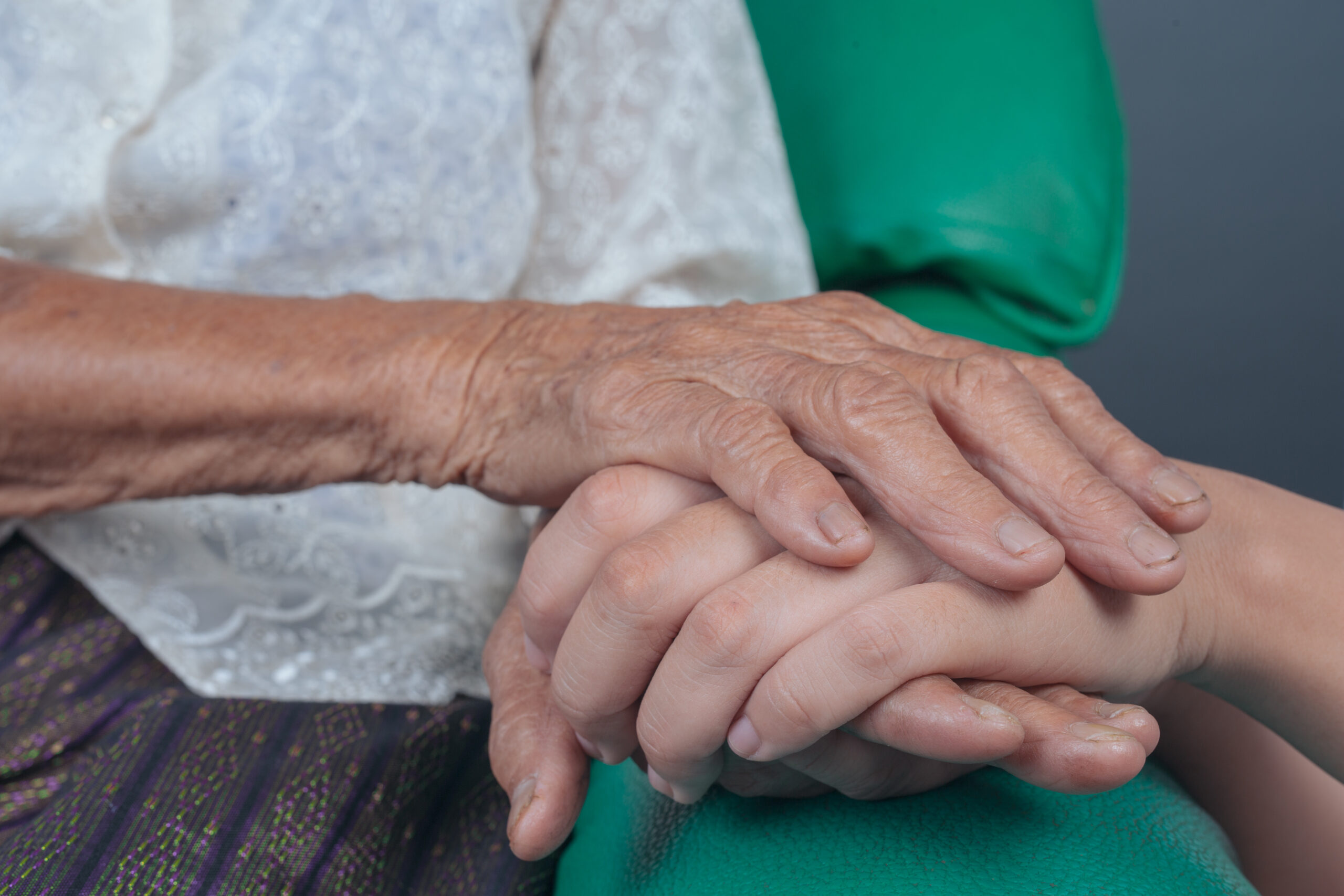 Young woman holding an elderly woman’s hand. Síntomas geriátricos como tratarlos
